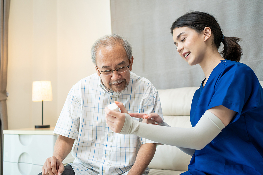 Medical assistant helping an elderly patient with their medication.