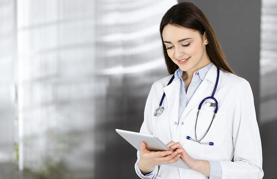 medical assistant looks at a tablet