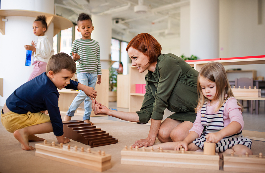 Preschool teacher working with young students.