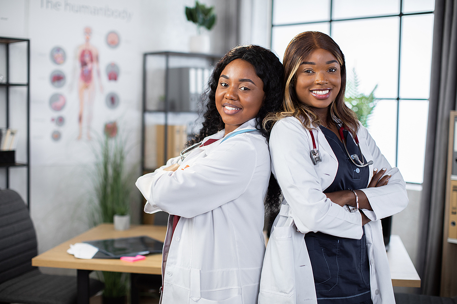 two medical assistants posing back to back