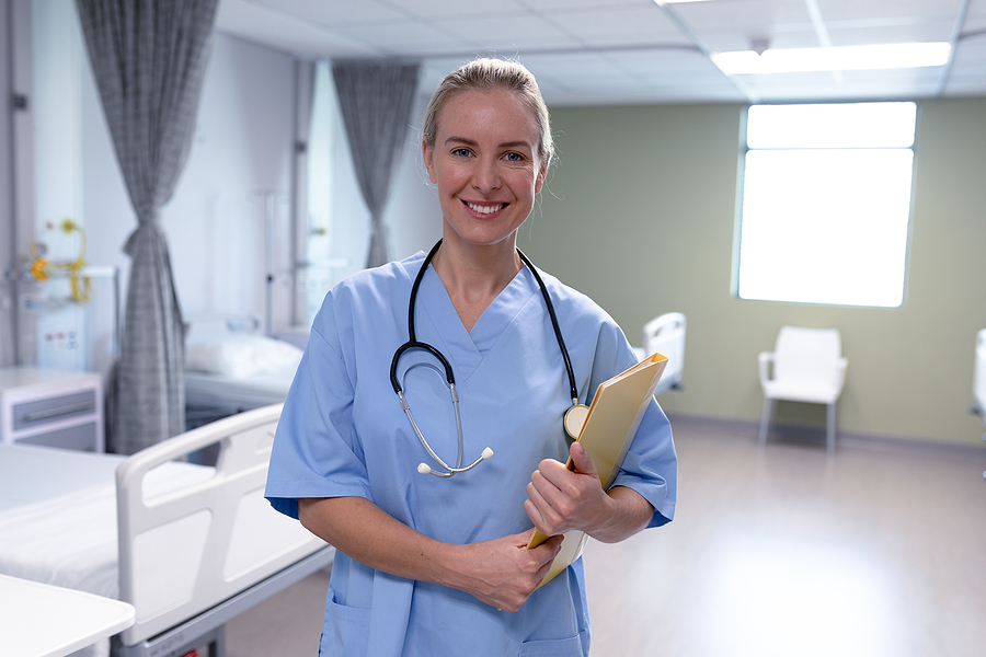 Medical assistant standing in a hospital room.