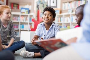 Blurred vision of a teacher reading to a group of young students. 