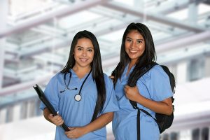 Two female nursing students standing in a medical facility with backpacks. 