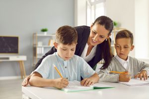 Female educator working with two students. 