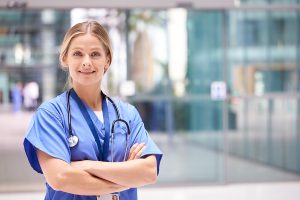 Female nurse standing outside of a medical building.