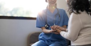 Closeup of a female nurse comforting a female patient.