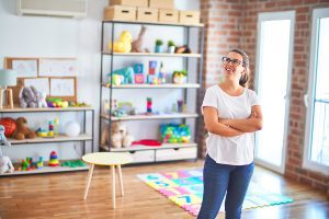 Preschool teacher standing in her decorated classroom.